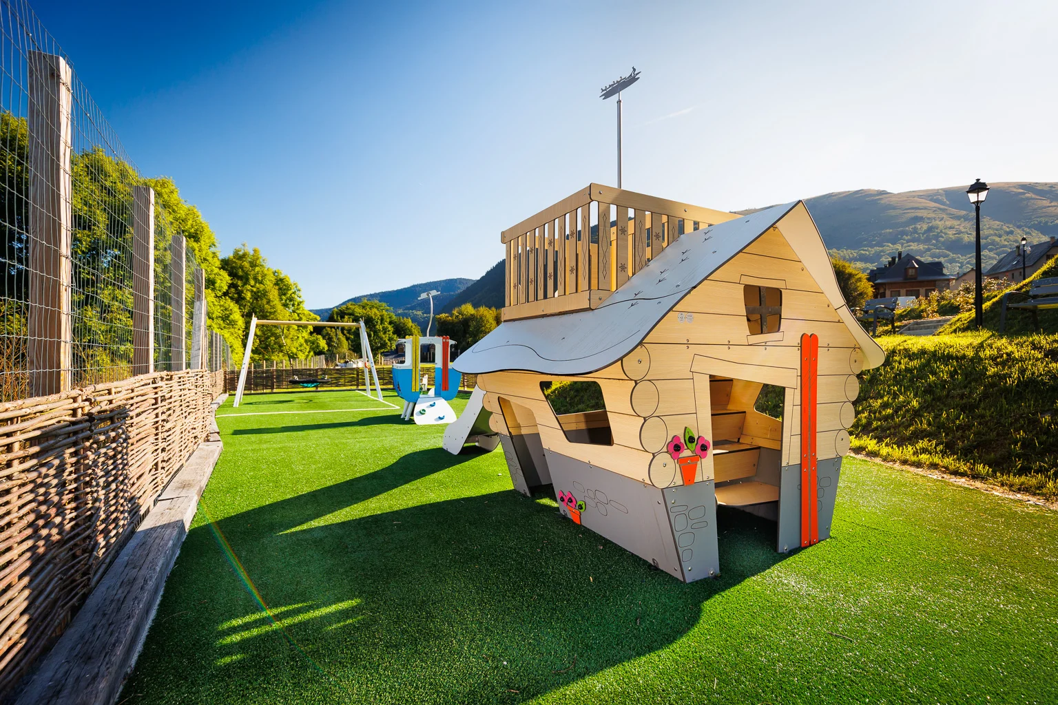 Cabane de jeux en bois sur gazon synthétique installée par C4D Solutions