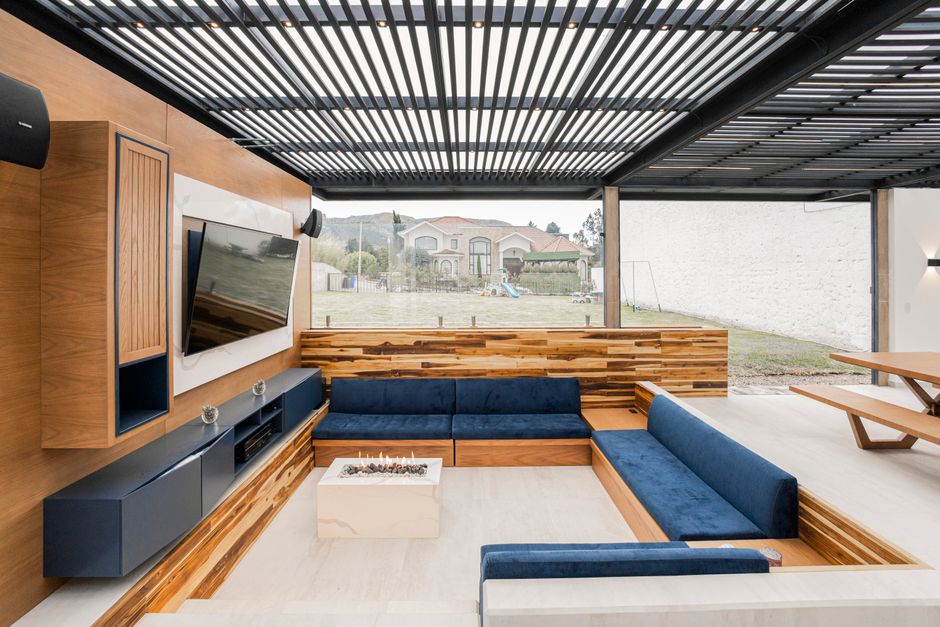 Pergola bioclimatique à lames orientables couvrant un salon extérieur
