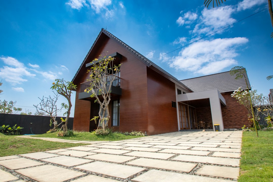 Maison contemporaine avec allée en dalles sur lit de galets et pelouse